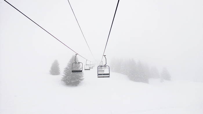 Ski lifts in a snowy winter landscape with pine trees