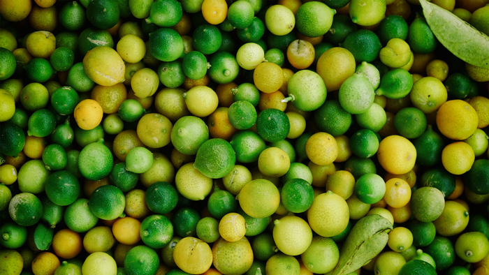 A pile of green and yellow limes and lemons