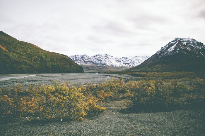 Mountain valley with snow-capped peaks and autumn foliage