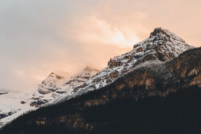 Snow-covered mountains at dawn with clouds