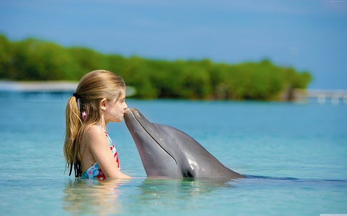 Girl kissing a dolphin in the ocean
