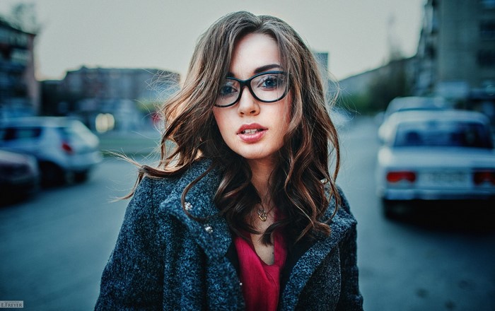 Woman with glasses and curly hair in a coat