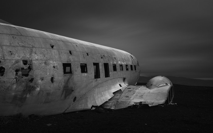 Abandoned airplane wreck on a dark landscape