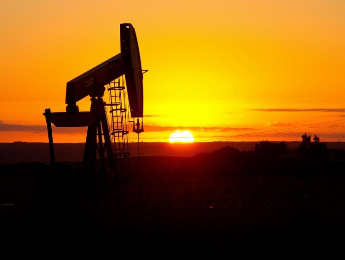 Oil pump silhouetted against a vibrant sunset