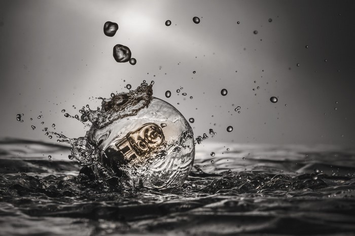 Lightbulb splashing into water with droplets
