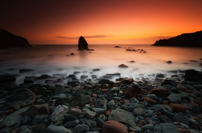 Rocky shore at sunset with ocean waves