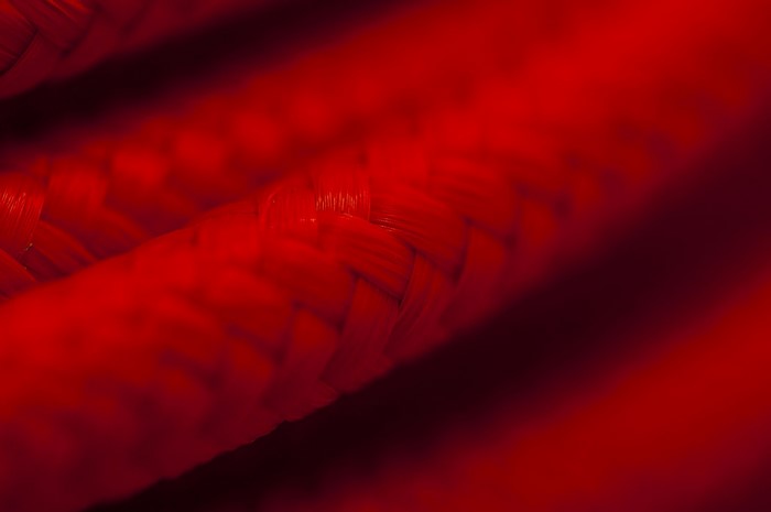 Close-up of red braided rope with shallow depth of field