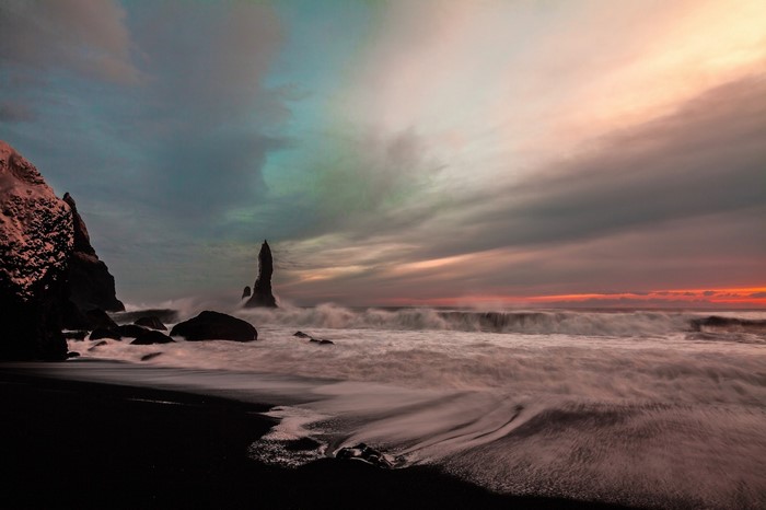 Black sand beach with sea stacks at sunset