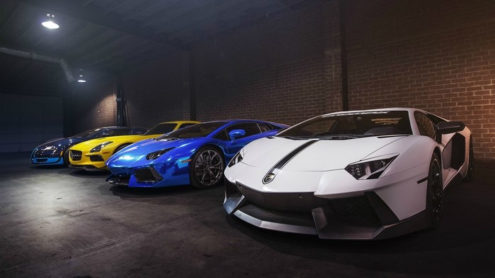 Four luxury sports cars parked in a garage
