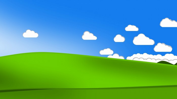 Green rolling hills under a blue sky with clouds