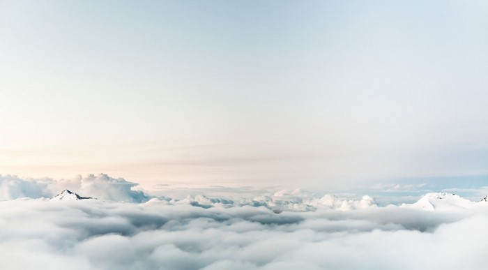 Snow-capped mountains above clouds at dawn