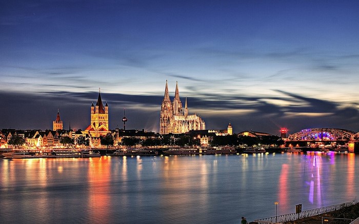 Cologne cityscape with cathedral and bridge at dusk