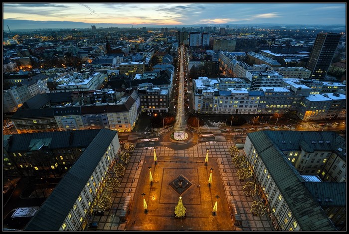Aerial view of a city square at dusk with Christmas tree