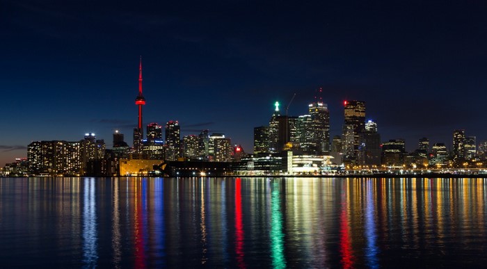 Toronto skyline at night with CN Tower and reflections