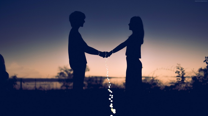 Couple holding hands at sunset 4K