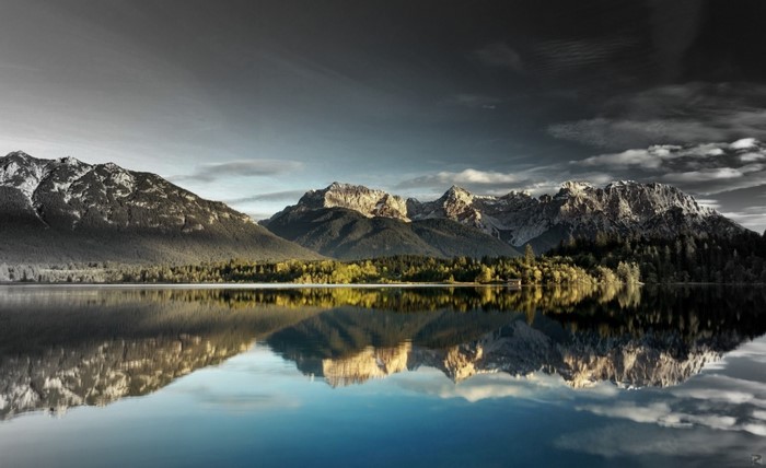 Mountain range reflected in a calm lake at sunrise