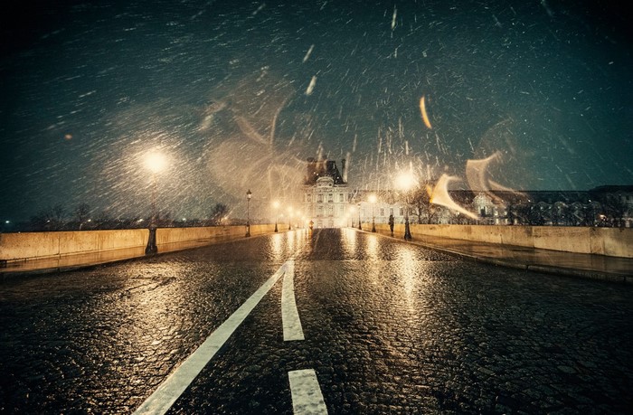 Paris street at night with snow and streetlights
