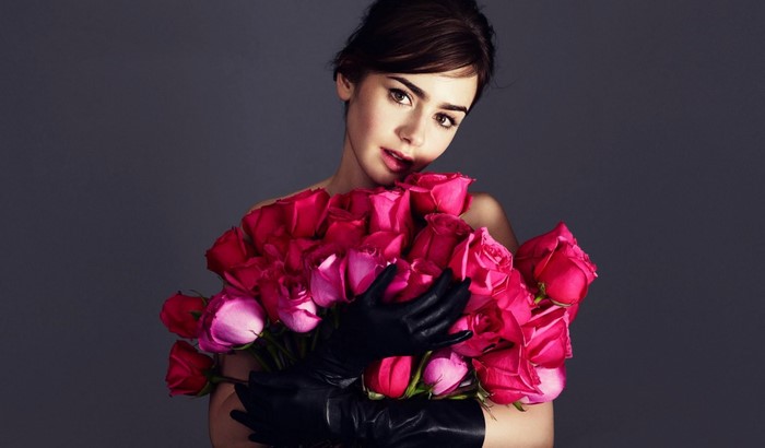 Lily Collins holding a bouquet of pink roses