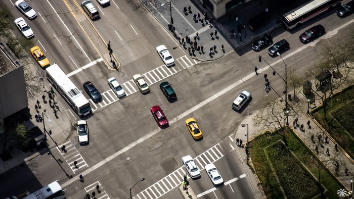 Aerial view of a busy city intersection with traffic and pedestrians