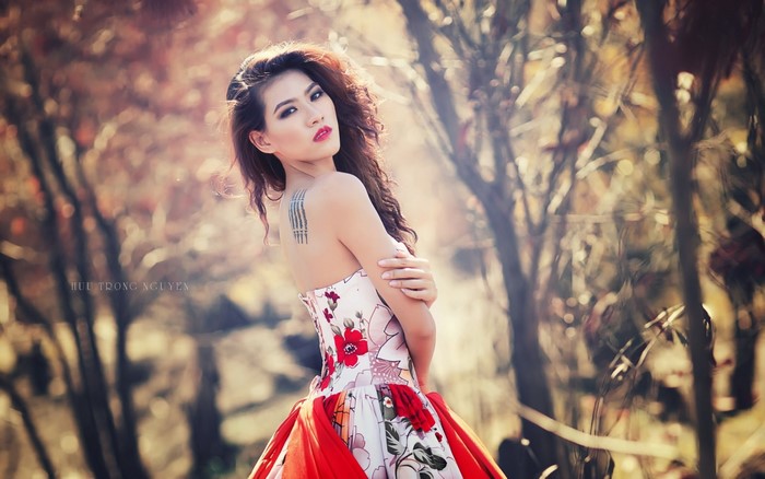 Woman in floral dress with red accents outdoors