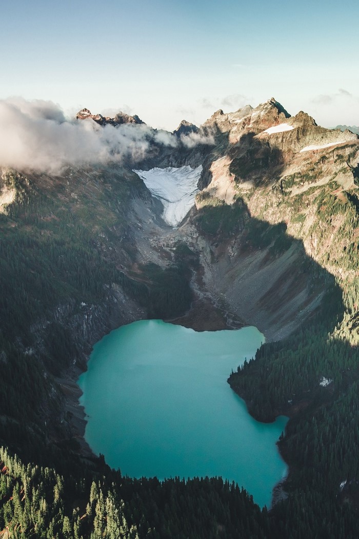 Turquoise lake nestled in a mountain valley with a glacier