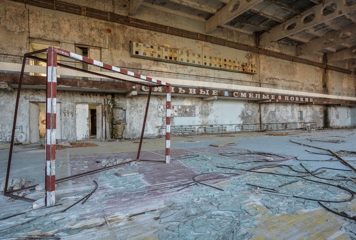 Abandoned gymnasium with goalposts and broken glass