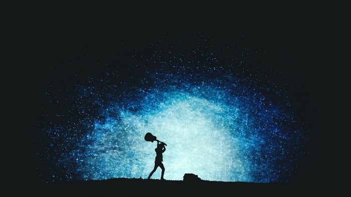 Silhouette of a person holding a guitar against a starry background