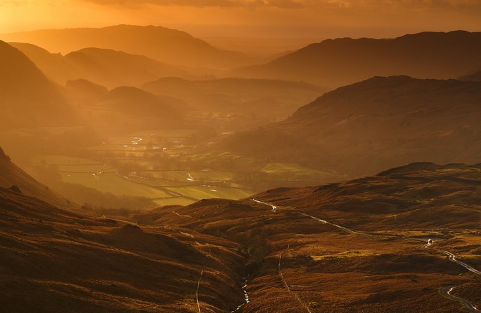 Sunlight over a mountain valley at sunset