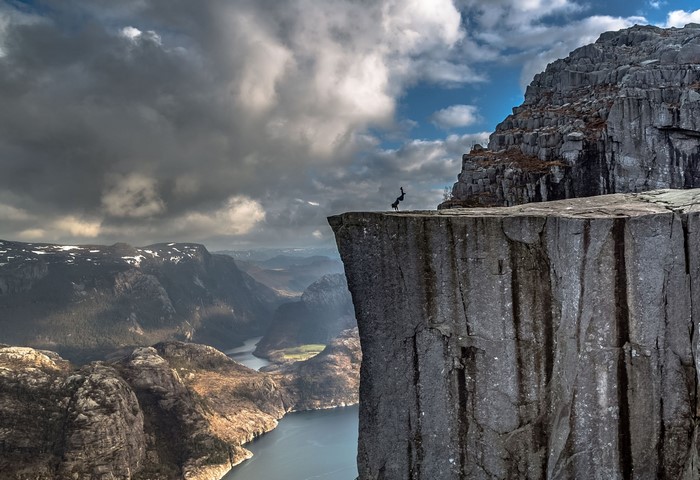 Person doing a handstand on a cliff edge in Norway