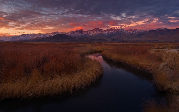 Sunset over mountains with river and marsh