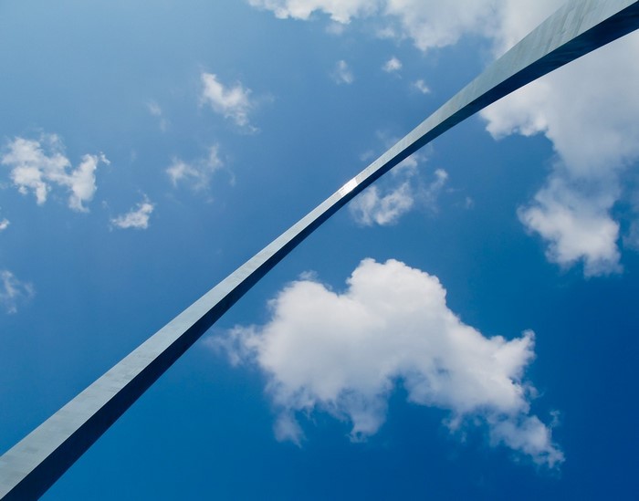 Gateway Arch against a blue sky with clouds