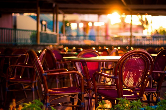 Outdoor restaurant tables and chairs at sunset