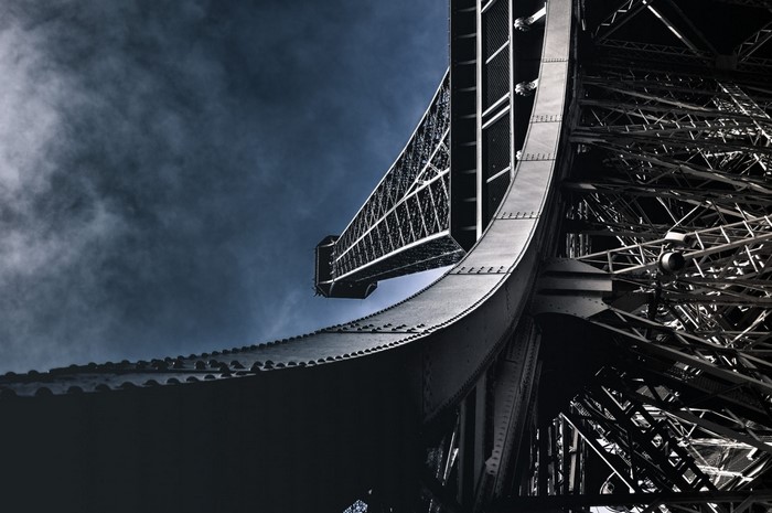 Eiffel Tower structure against a cloudy sky