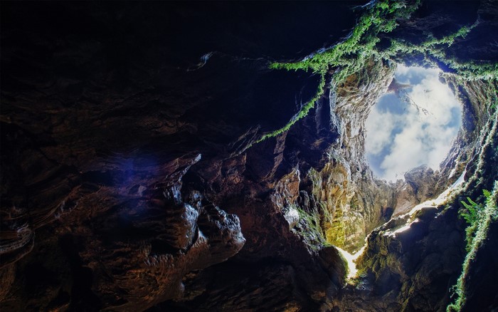 View from inside a cave looking up at the sky
