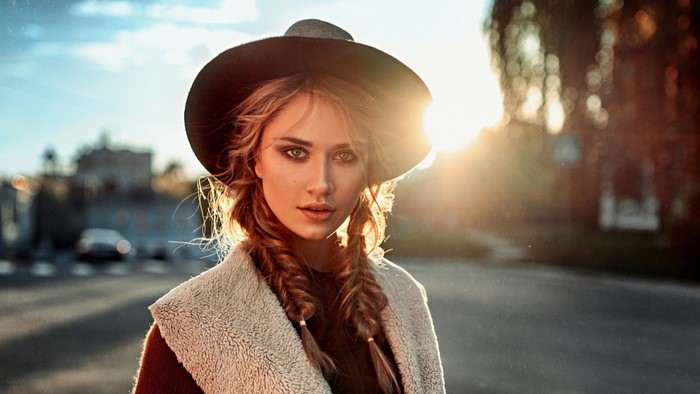 Woman wearing a hat and coat with braids