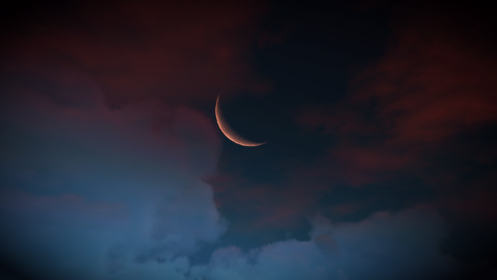 Crescent moon in cloudy sky