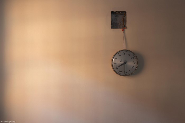 Wall clock hanging from electrical box