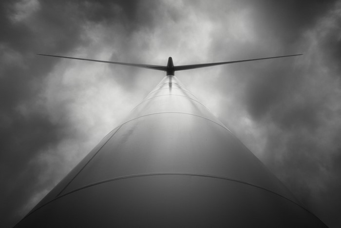 Low angle view of a wind turbine against a cloudy sky