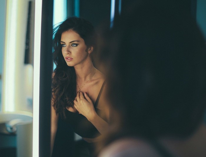 Woman looking in a mirror with blue eyes