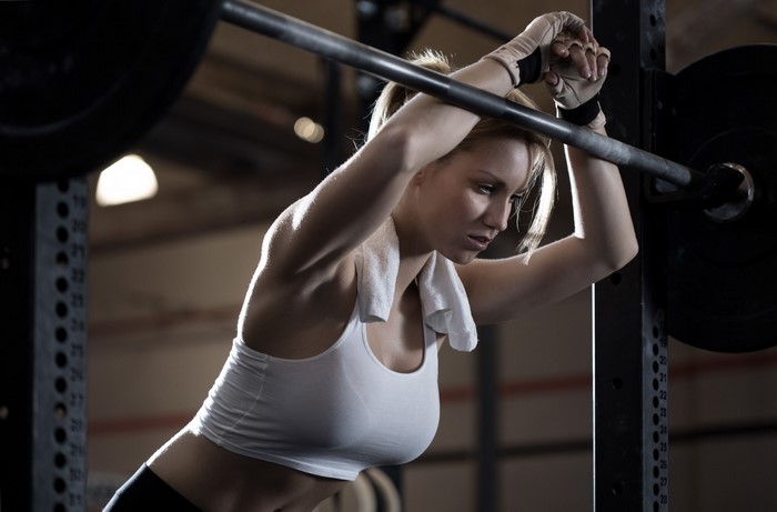 Focused Woman Preparing to Lift Barbell at Gym