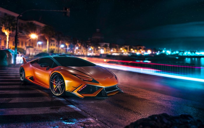 Orange Lamborghini Huracan on a city street at night