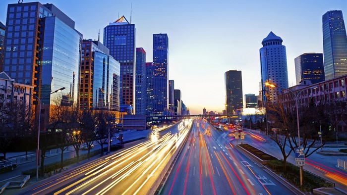Beijing cityscape with light trails on highway at dusk