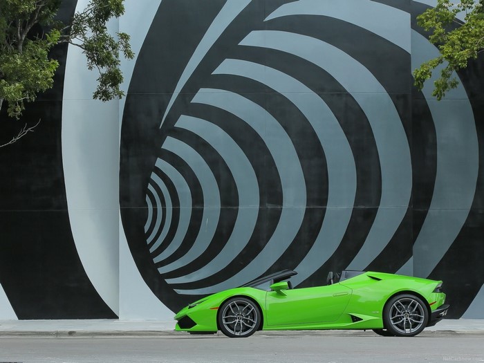 Green Lamborghini Huracan Spyder parked by a mural