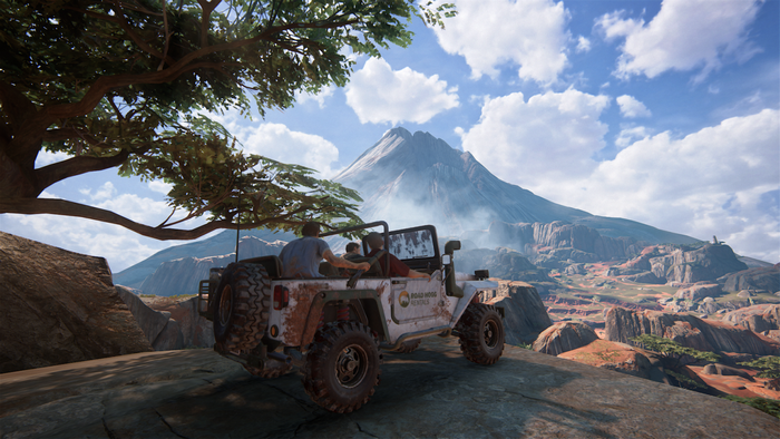 Nathan Drake and Sully in a jeep with a volcano in the background