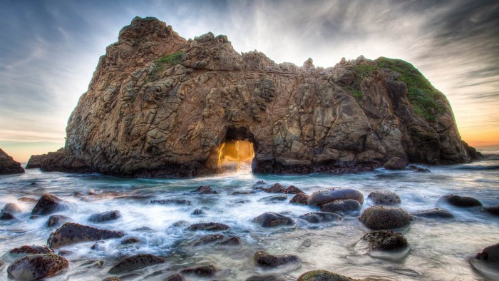 Rocky cove with ocean waves and a natural arch