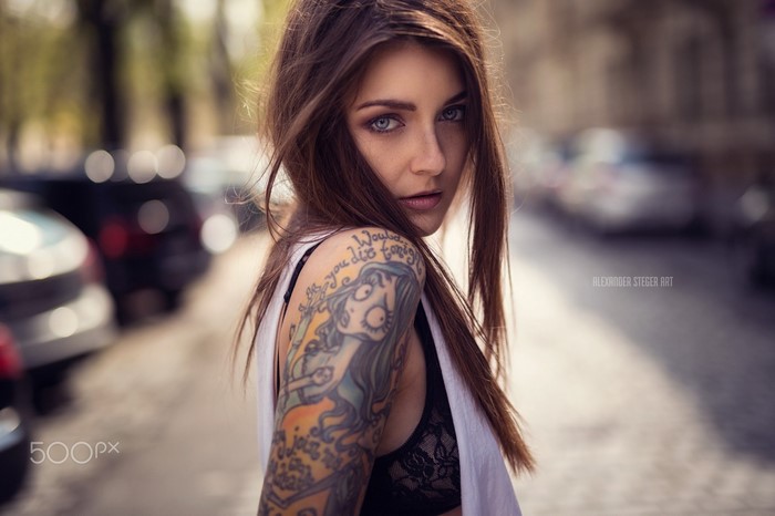 Woman with tattoos and blue eyes on street