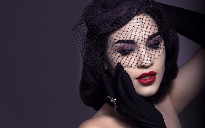 Woman in black veil and gloves with red lipstick