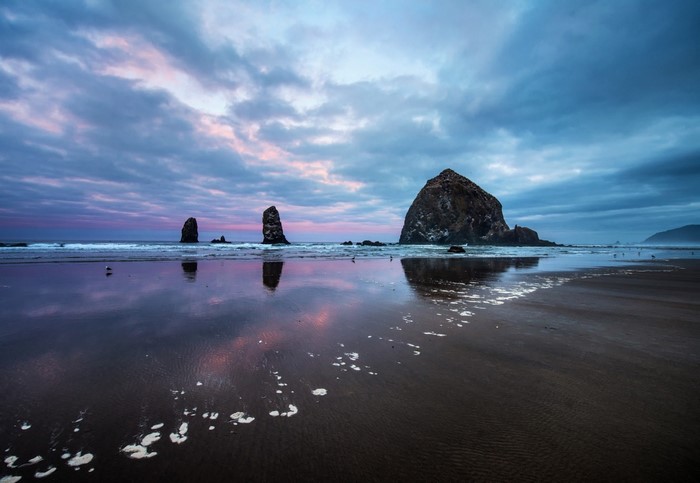 Haystack Rock and sea stacks at Cannon Beach during sunset