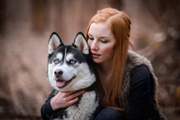 Woman with Red Hair Hugging a Siberian Husky Dog