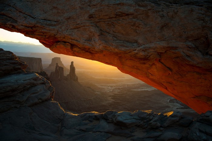 Sunlit Cave Overlooking Rocky Landscape at Dawn